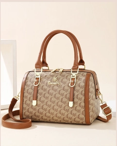 Detail of Boston handbag featuring geometric letter print and gold hardware logos