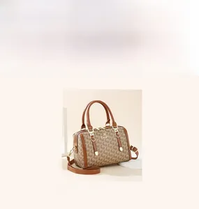 Detail of Boston style handbag with brown letter pattern and round leather handles