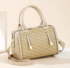 Close-up of beige monogram Boston bag with golden hardware and adjustable strap