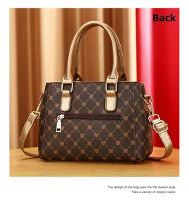 Detail view of the back zipper pocket on a brown patterned leather handbag with gold accents