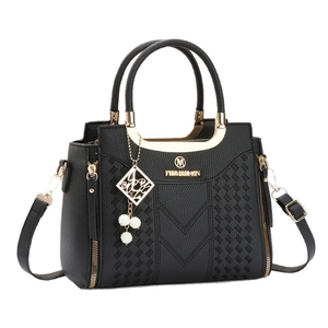 Sac à main noir en cuir grainé de grande capacité avec détails dorés et pompon élégant