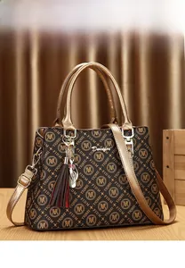 Détail d'un sac cabas en cuir marron à motifs avec breloque chat et pompon élégant