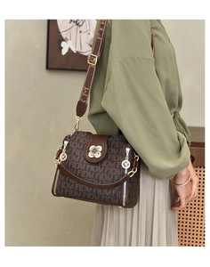 Gros plan détaillé du sac bandoulière monogramme marron avec boucle fleur dorée élégante