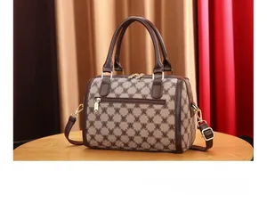 Detail showing the back zipper pocket and brown leather trim of the monogram crossbody bag