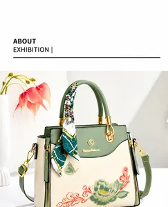 Detail of floral butterfly embroidery on green and beige tote bag with a silk scarf handle