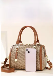 Detail of Boston handbag with logo pattern and iPhone for size reference