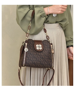 Détail d'un sac à main à monogramme avec fermoir trèfle doré et poignée en chaîne élégante