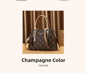 Gros plan du sac cabas monogramme champagne avec breloque chat en métal sur bois
