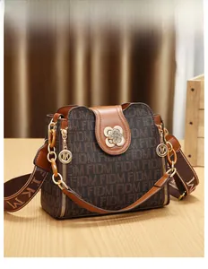 Détail d'un sac à main vintage monogrammé avec fermoir trèfle doré et bandoulière large