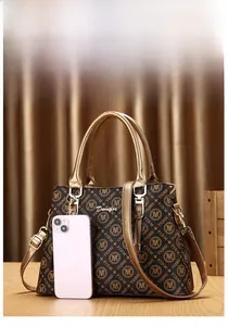 Détail du sac à main monogramme marron foncé avec poignées dorées et smartphone pour taille