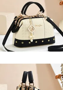 Close-up of contrast crossbody bag featuring lychee grain leather and pearl charm