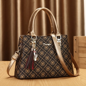 Brown monogram tote bag with gold handles and cat charm shown in 2-piece set