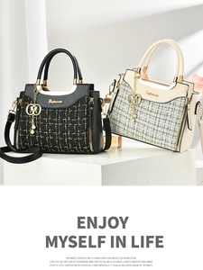Close-up of woven tweed texture and elegant pearl charm on minimalist crossbody handbag