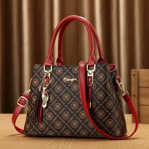 Sac à main monogramme marron avec poignées en cuir rouge et pendentif chat en métal