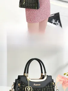 Detail of tweed and leather tote bag with gold metal handle and logo ornament