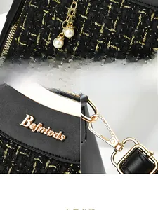 Detail of black tweed handbag with golden hardware, brand logo, and pearl charm pendant