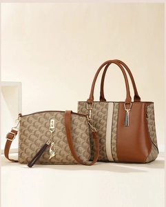 Detail of 2-piece tote bag set in brown monogram with a cute gold cat charm accessory