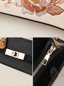 Détail de la broderie florale et du fermoir rotatif en métal doré sur le sac à main
