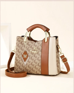 Detailed view of the monogram patterns and brown leather accents on a stylish tote bag