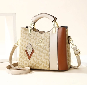 Detail showing the monogram pattern and golden Denisa logo on the tricolor tote bag