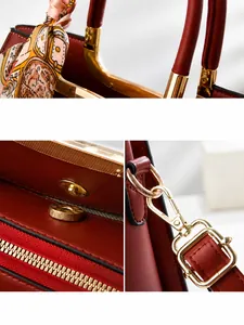 Details einer roten Lederhandtasche mit goldener Hardware und Seidenschal-Dekor