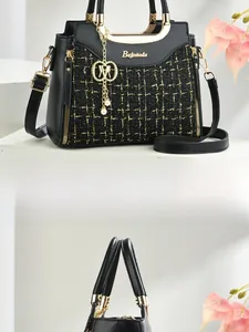 Detail of black tweed crossbody bag featuring gold hardware and pearl charm accents