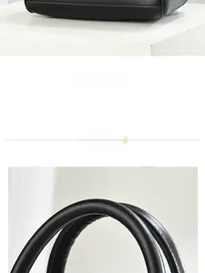 Detailed view of the black leather handbag's flat bottom structure and smooth rounded handle