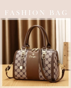 Close-up of vintage patterned fabric with gold logo detail on a classic Boston handbag