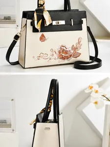 Gros plan détaillé de la broderie florale sur un sac à main blanc et noir