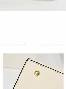 Détail du bas de sac en cuir beige avec pieds en métal doré et coutures précises