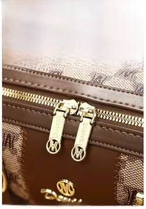 Macro shot of dual golden zippers and jacquard fabric on stylish women handbag