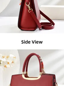 Detail view of red Chinese style handbag with silk scarf handle and golden hardware