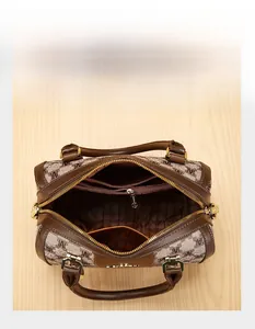 Detailed interior of brown patterned Boston bag with zipper pockets and striped lining