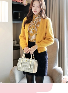 Detailed view of women's tweed boston bag with gold hardware and ivory leather trim