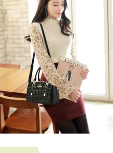 Close-up of black and gold tweed Boston bag with leather handles in a cafe setting