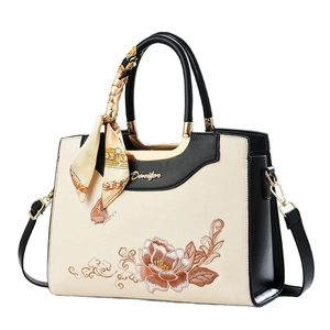 Elegant white and black embroidered handbag with floral pattern and silk scarf handle