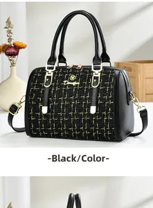 Detail of black tweed Boston bag with gold M logo and adjustable leather shoulder strap