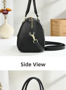 Detail view of the sleek black leather side profile and gold hardware on this handbag