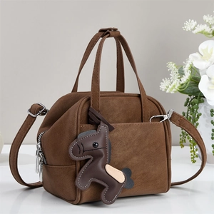 Brown faux leather crossbody bag with horse charm pendant and adjustable shoulder strap