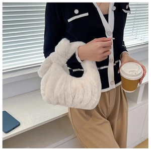 Detail showing plush faux fur texture and ruched knot handle of ivory white tote bag