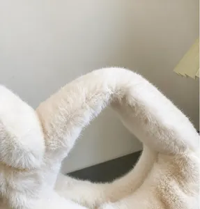 Close-up of soft faux fur texture and comfortable wide handle of the plush white handbag
