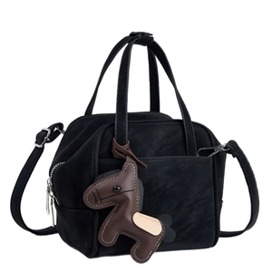Black suede handbag with brown horse charm and detachable strap in a front view