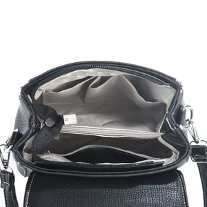 Detail view of the black handbag interior featuring multiple compartments and grey lining