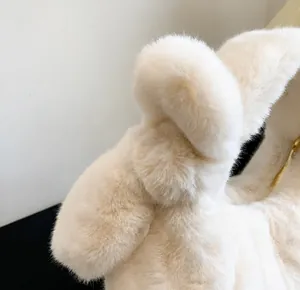Macro detail of the plush cream white faux fur texture with a soft bow design