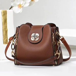 Sac bandoulière élégant en cuir marron avec fermoir trèfle et bandoulière dorée