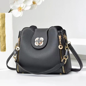 Détail du sac à bandoulière en cuir noir avec fermoir trèfle et finitions dorées