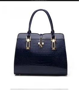 Detailed front view of dark blue crocodile pattern handbag with gold metal lock