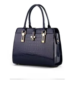 Detail view showing navy blue croc-embossed glossy leather and golden metal clasp