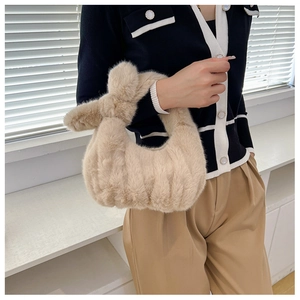 Detailed close-up of fluffy beige faux fur handbag with knotted handle and pleated texture