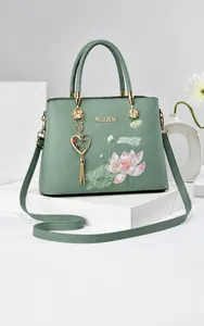 Close-up of lotus embroidery and heart tassel on light green Chinese style handbag